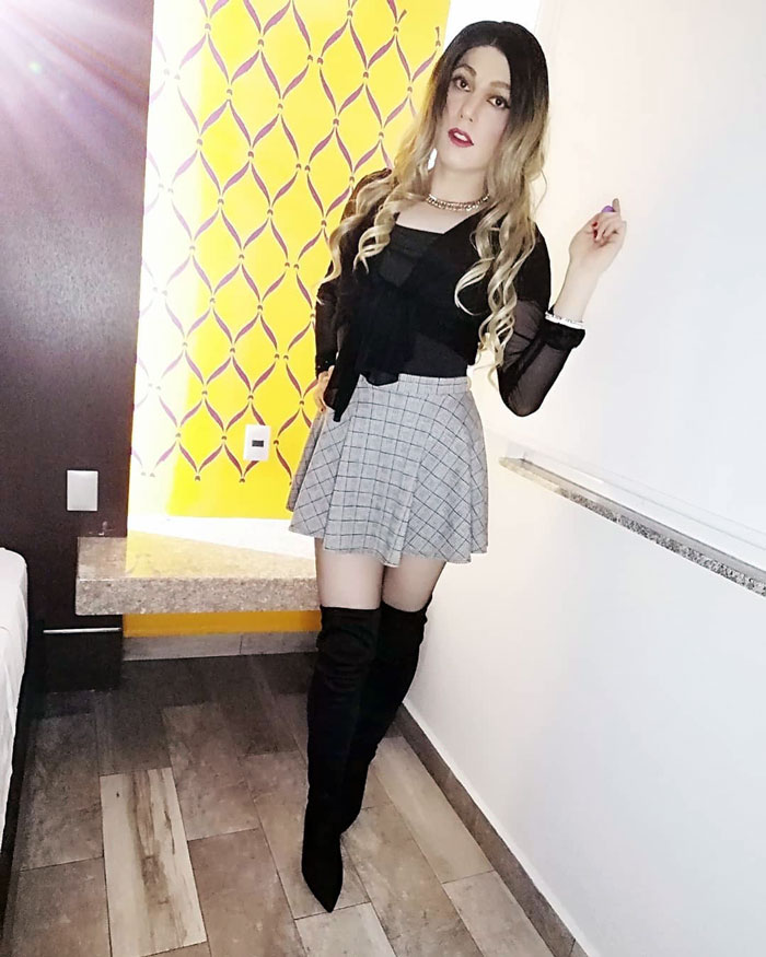 Laura crossdressing in skirt and boots